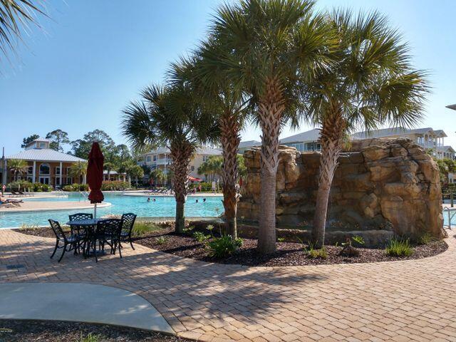 8700 Front Beach Road, Unit 5313 Panama City Beach, FL 32407 - Photo 33 of 38 a view of a patio with a dining table and chairs under an umbrella