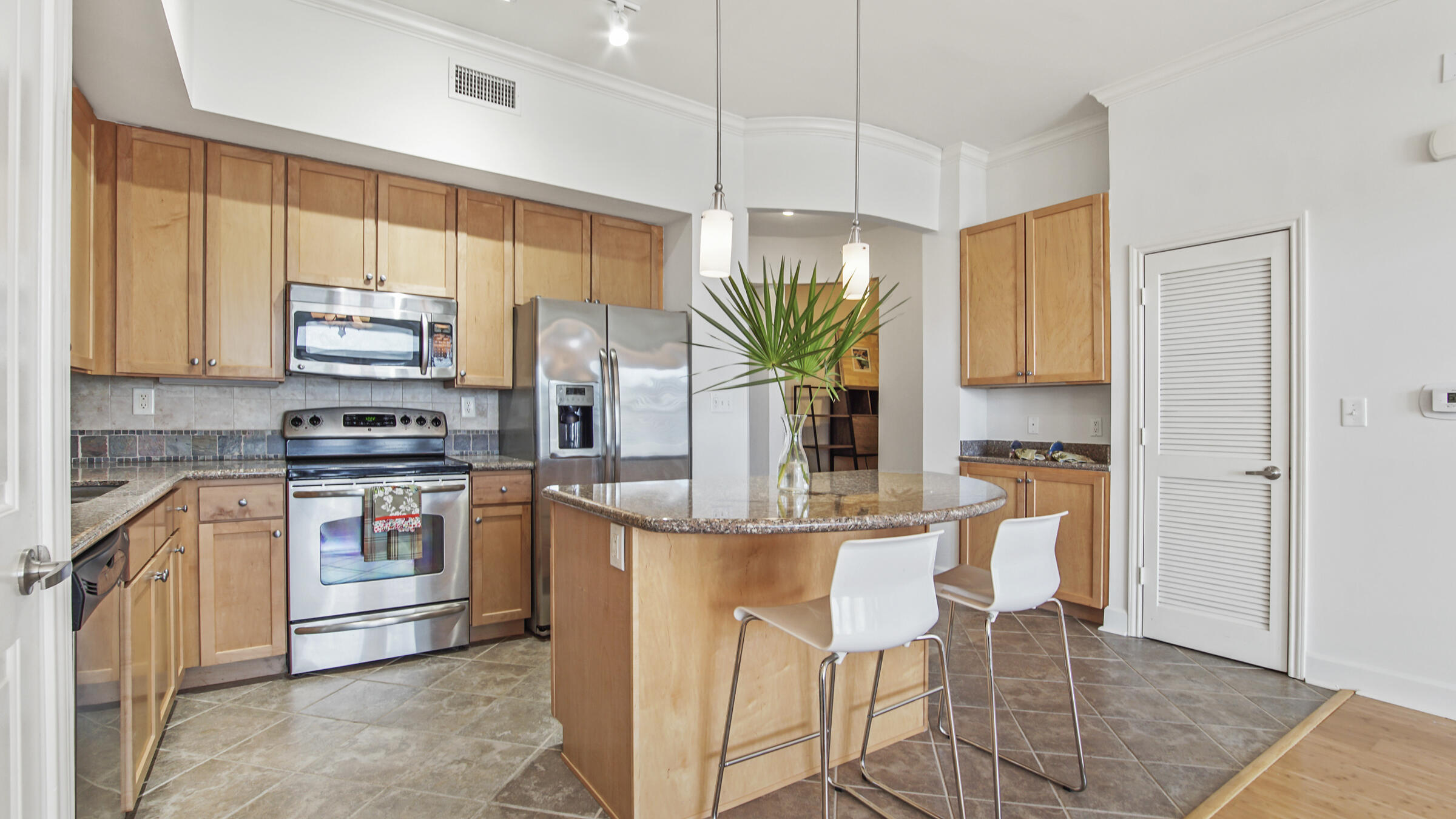 8700 Front Beach Road, Unit 5313 Panama City Beach, FL 32407 - Photo 10 of 38 a kitchen with stainless steel appliances granite countertop a stove a sink a microwave a dining table and chairs