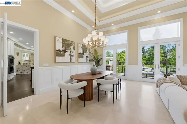 a living room with furniture a chandelier and a dining table