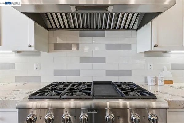 a kitchen with stainless steel appliances granite countertop a sink stove and cabinets