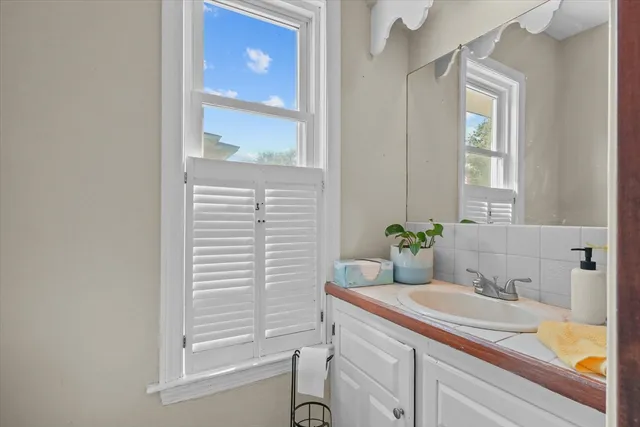 a bath room with a sink and a large mirror