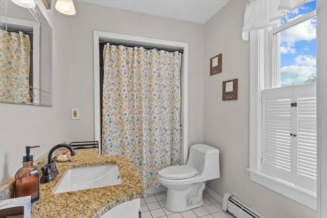 a bathroom with a sink a toilet and shower curtain