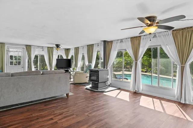 a living room with fireplace furniture and a large window
