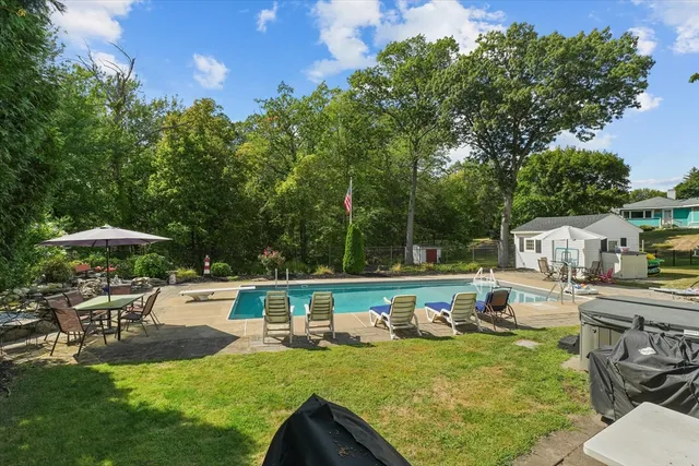 a view of a house with backyard sitting area and swimming pool