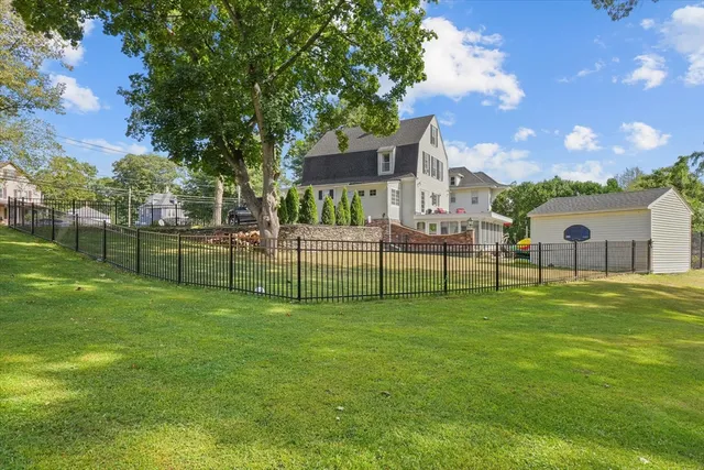 a view of a house with a big yard and a large tree