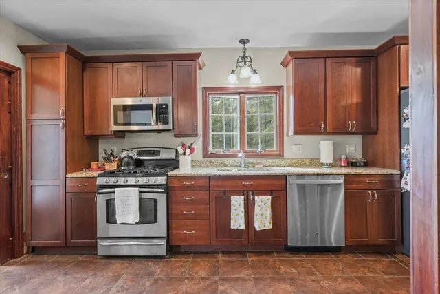 a kitchen with stainless steel appliances granite countertop a stove a sink dishwasher a refrigerator and a microwave oven