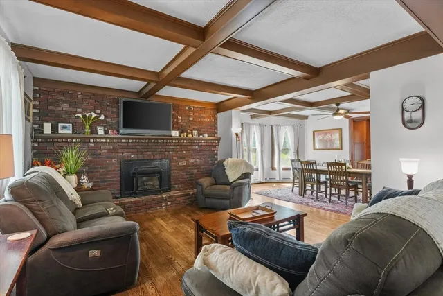a living room with furniture a fireplace and a large window