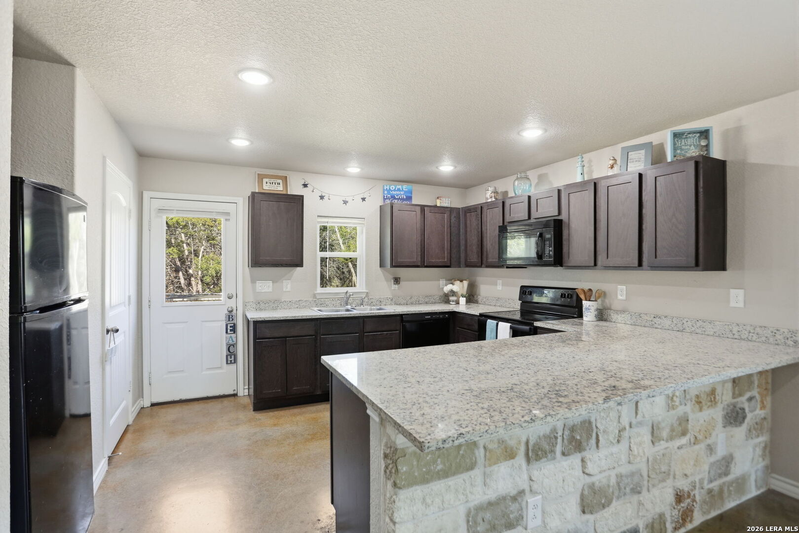 341 Ridge Road Spring Branch, TX 78070 - Photo 7 of 23 a kitchen with stainless steel appliances granite countertop a sink refrigerator and cabinets