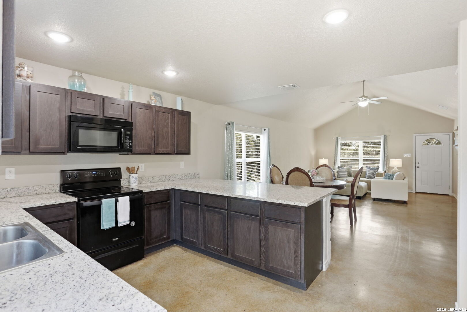 341 Ridge Road Spring Branch, TX 78070 - Photo 9 of 23 a kitchen with stainless steel appliances granite countertop a sink dishwasher stove and microwave with wooden cabinets