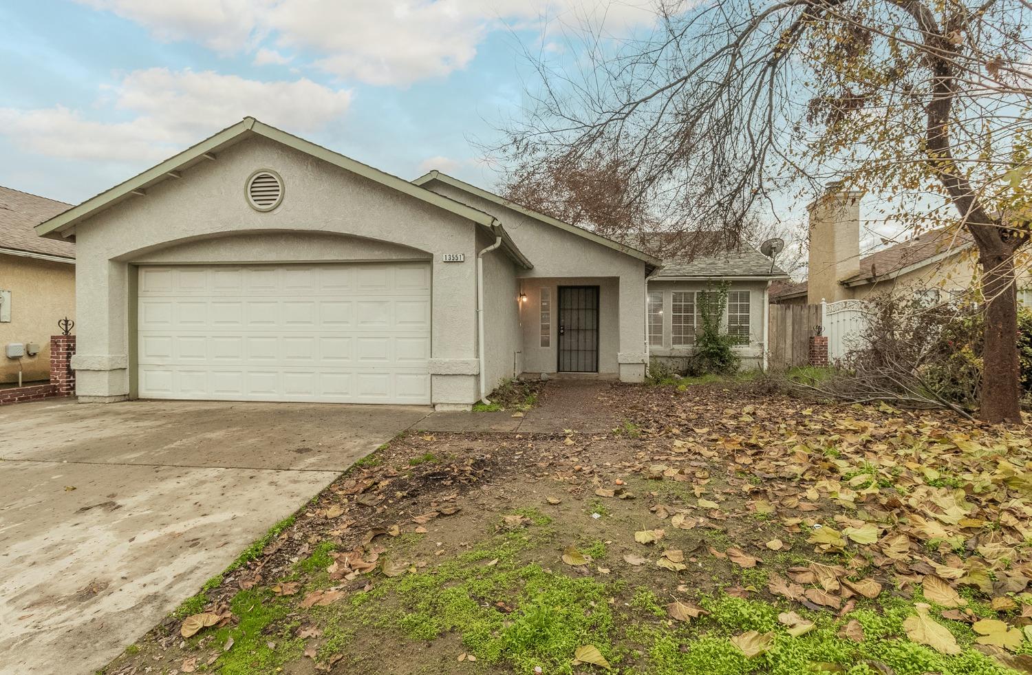 13551 7th Street Parlier, CA 93648 - Photo 1 of 17 a front view of a house with a yard and garage