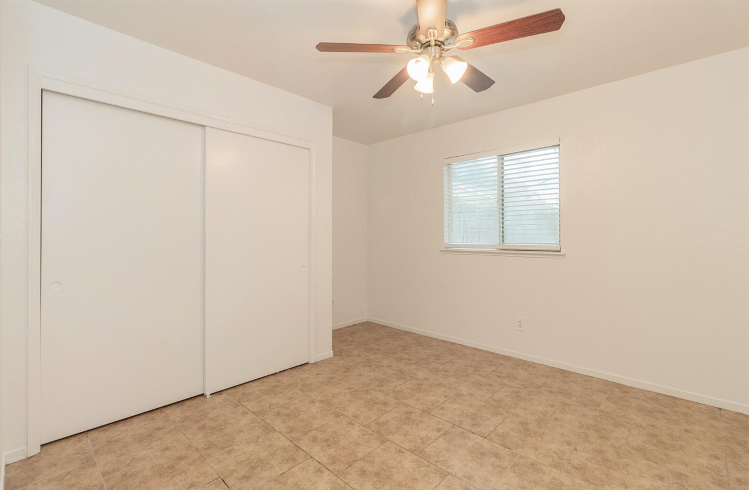 13551 7th Street Parlier, CA 93648 - Photo 14 of 17 an empty room with windows and fan