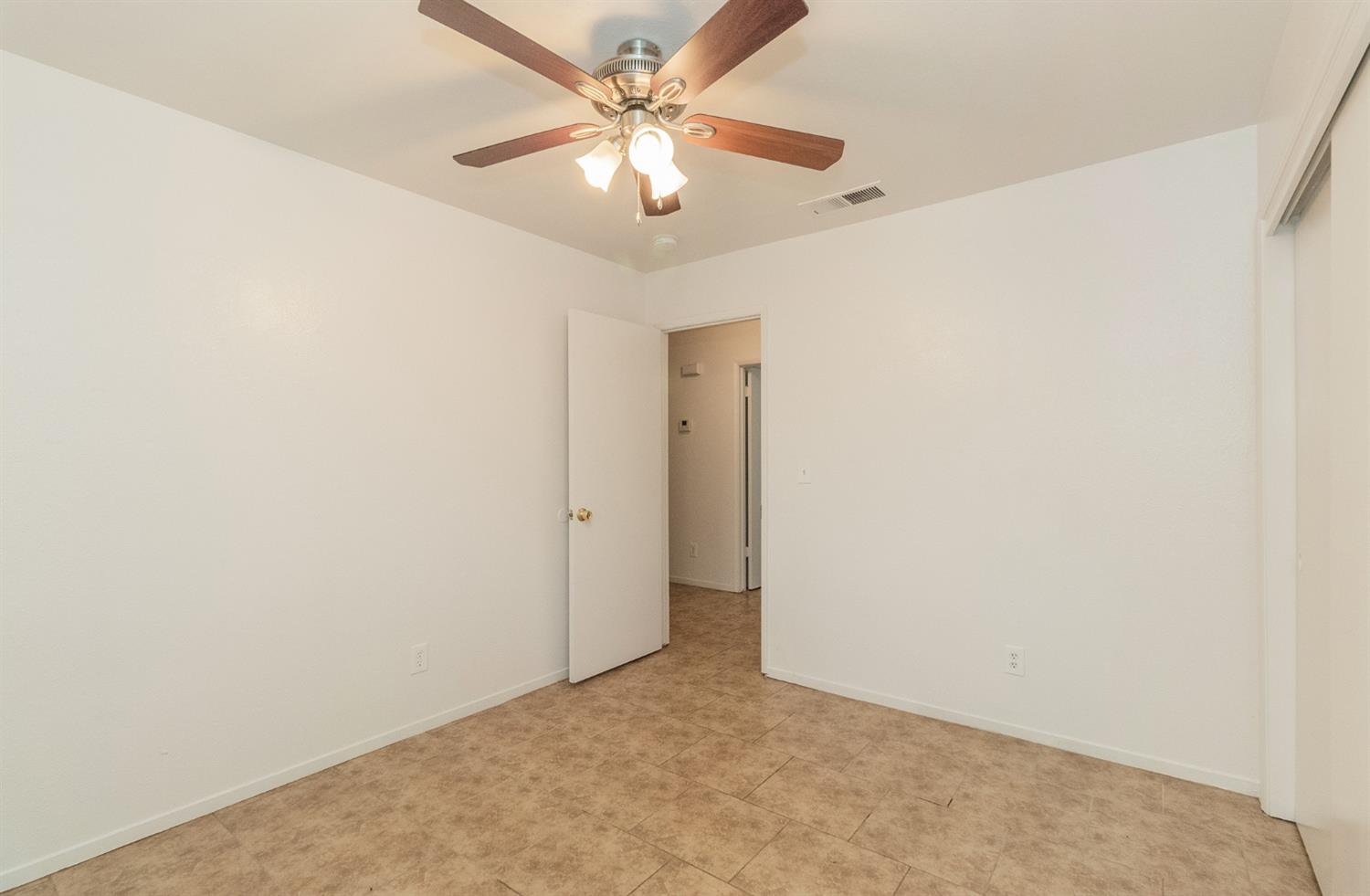 13551 7th Street Parlier, CA 93648 - Photo 16 of 17 an empty room with a chandelier fan and closet