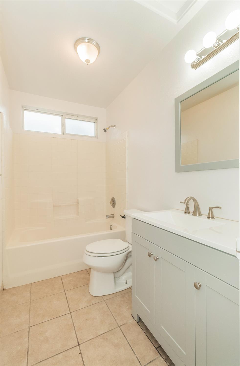 13551 7th Street Parlier, CA 93648 - Photo 17 of 17 a bathroom with a toilet a sink a mirror and bathtub