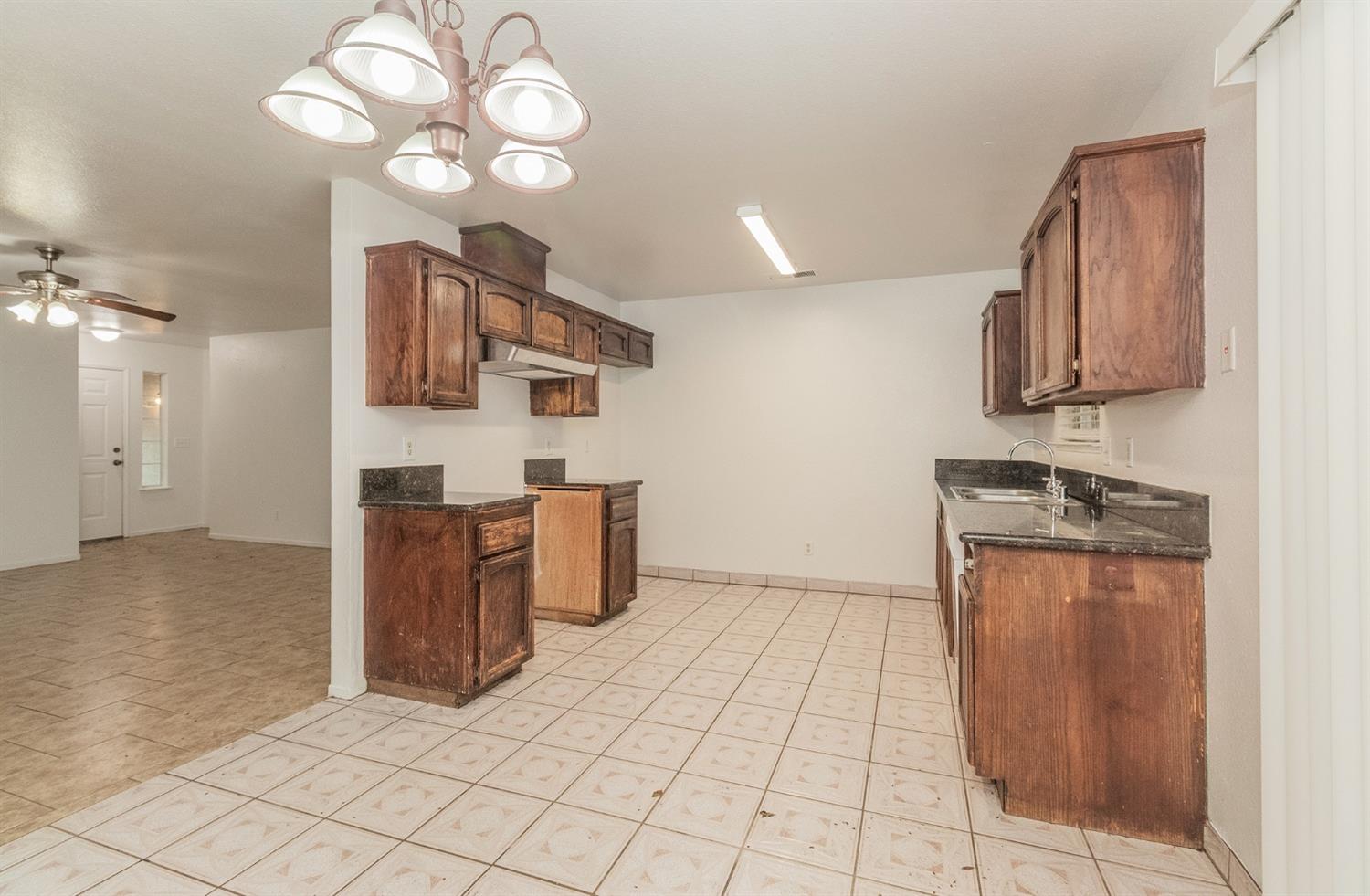 13551 7th Street Parlier, CA 93648 - Photo 5 of 17 a kitchen with stainless steel appliances granite countertop a stove a sink and a refrigerator