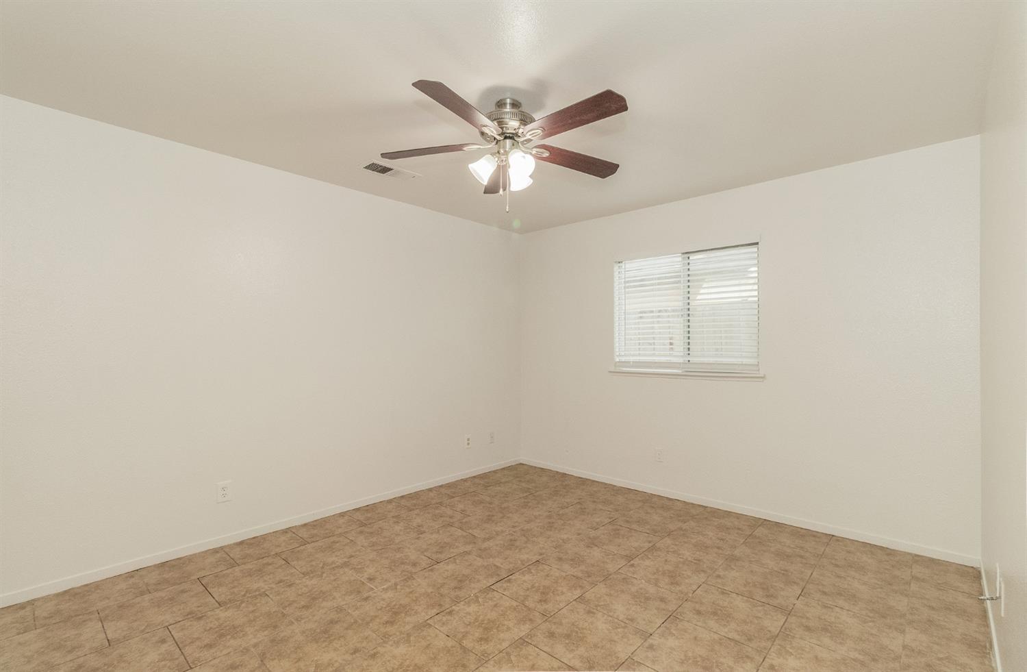 13551 7th Street Parlier, CA 93648 - Photo 8 of 17 a view of a ceiling fan and window