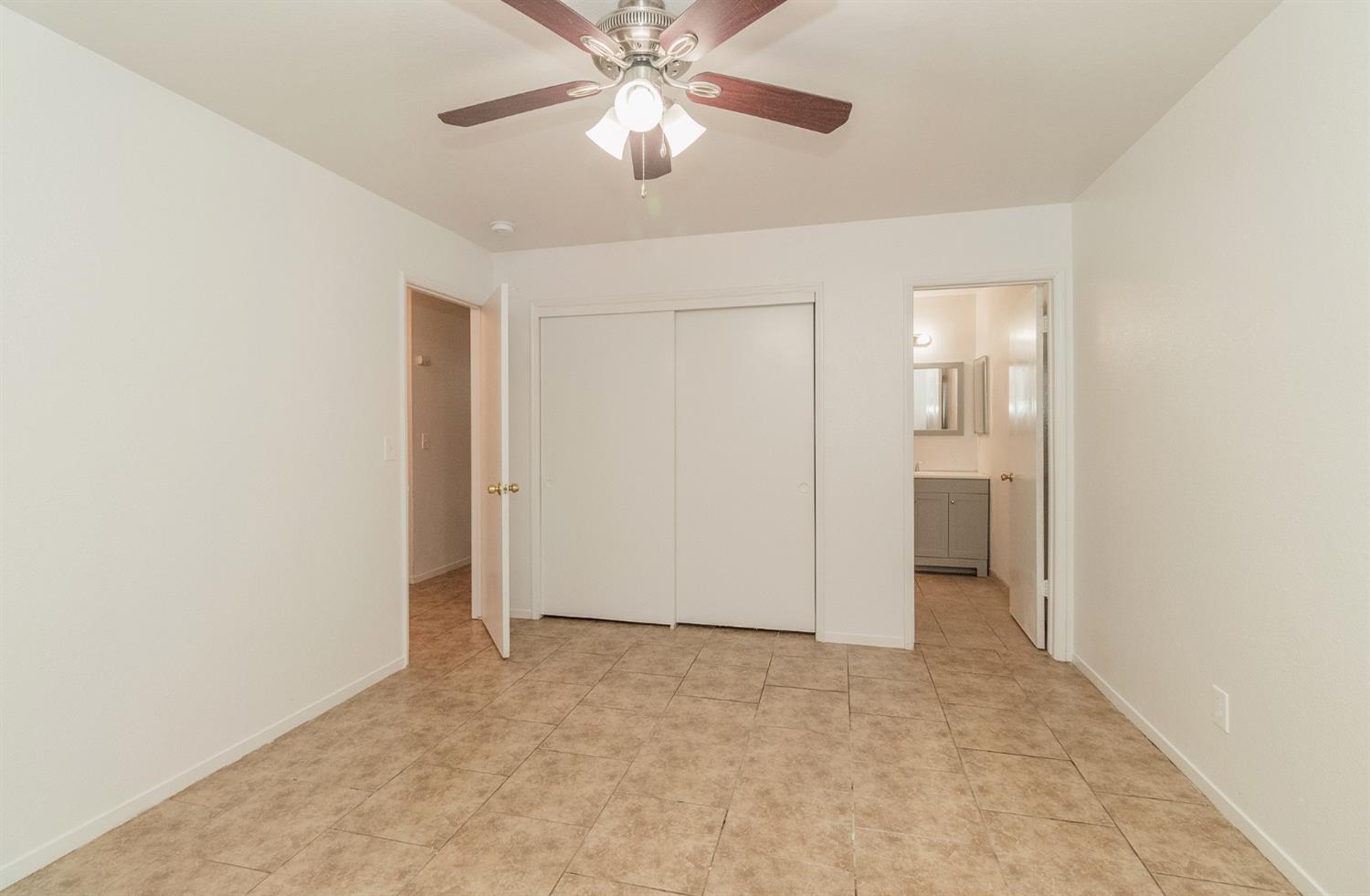 13551 7th Street Parlier, CA 93648 - Photo 9 of 17 an empty room with closet and a chandelier fan