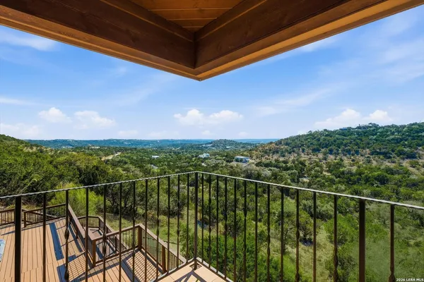 a view of a balcony with a floor to ceiling window and wooden fence