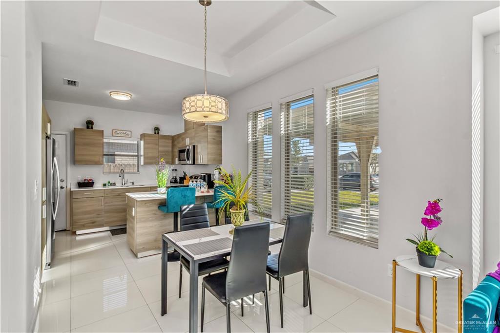 5708 Nightingale Avenue, Unit 2 Mission, TX 78573 - Photo 3 of 12 Tiled dining space featuring a raised ceiling, a healthy amount of sunlight, and sink