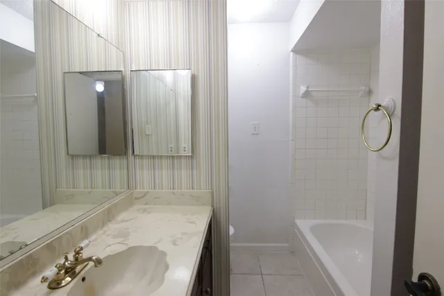 a bathroom with a tub sink and shower