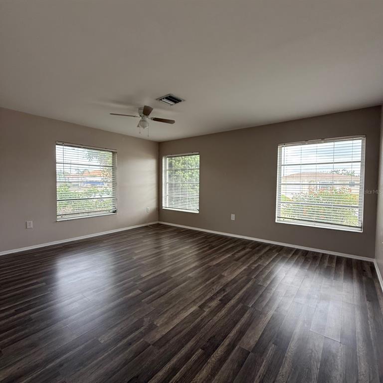 201 San Marco Avenue, Unit 1 North Port, FL 34287 - Photo 2 of 13 an empty room with wooden floor and windows