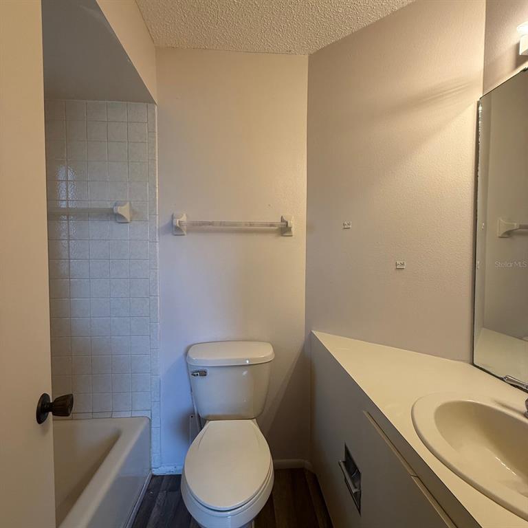 201 San Marco Avenue, Unit 1 North Port, FL 34287 - Photo 8 of 13 a white toilet sitting next to a bathroom sink and a tub