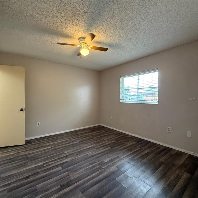 201 San Marco Avenue, Unit 1 North Port, FL 34287 - Photo 9 of 13 a view of an empty room with wooden floor and a window