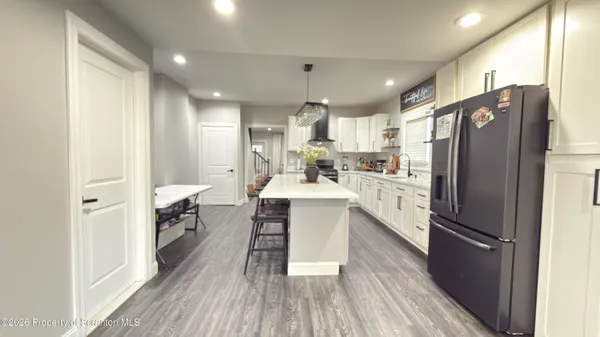 a kitchen with refrigerator cabinets and wooden floor
