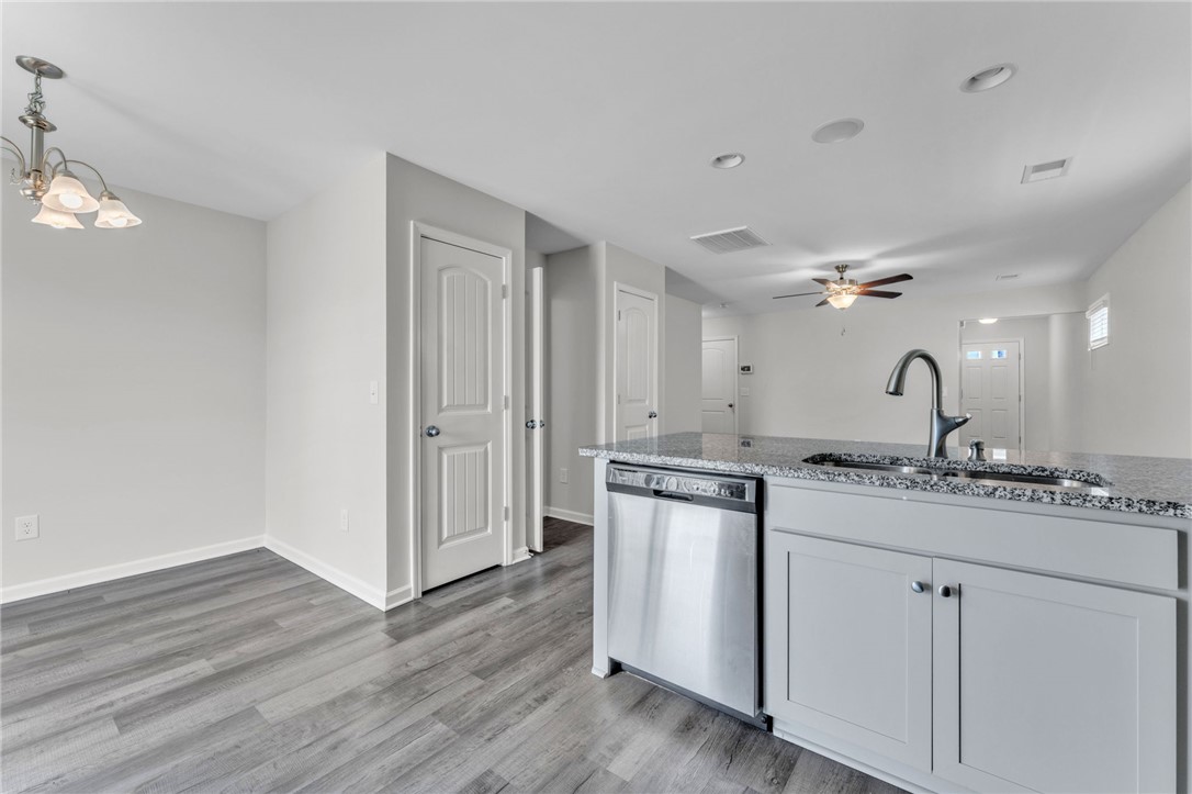 208 Samuel Street Pendleton, SC 29670 - Photo 10 of 32 A sleek island kitchen featuring a stainless dishwasher, modern sink, and durable granite counters.