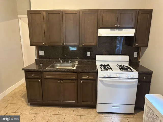 a kitchen with a sink a stove and cabinets