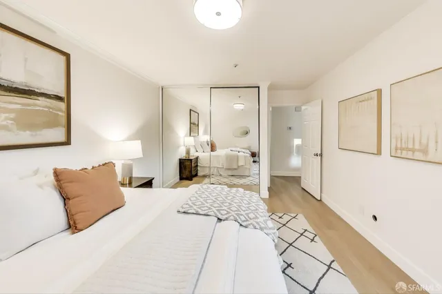 a bedroom with a bed and a painting on the wall