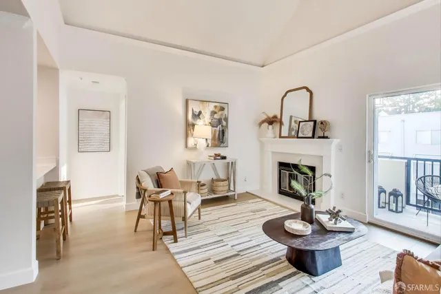 a living room with furniture a fireplace and a table
