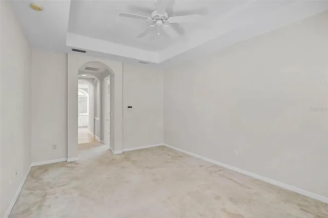 an empty room with a windows and ceiling fan