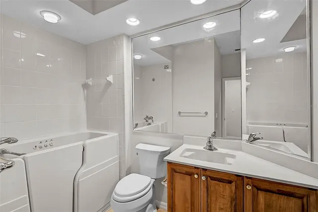 a bathroom with a sink a toilet a mirror and shower