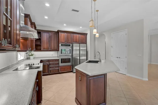 a kitchen with stainless steel appliances granite countertop a sink a stove and a refrigerator
