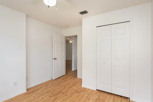 a view of an empty room with wooden floor