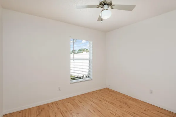 a view of an empty room with a window and a ceiling fan