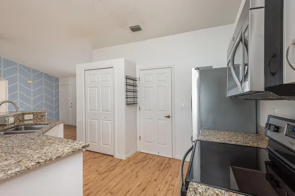 a kitchen with granite countertop a stove and a sink