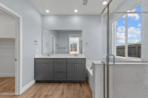 a spacious bathroom with a granite countertop sink a mirror and a shower