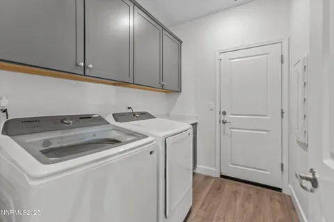 a utility room with wooden floor washer and dryer