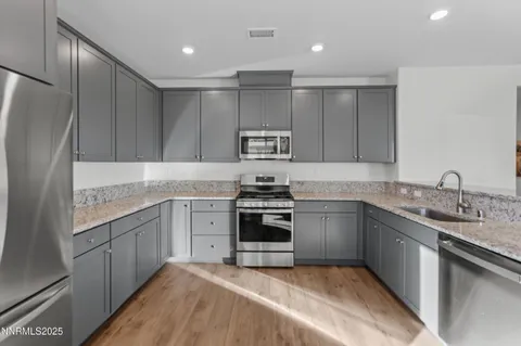 a kitchen with granite countertop stainless steel appliances and wooden cabinets