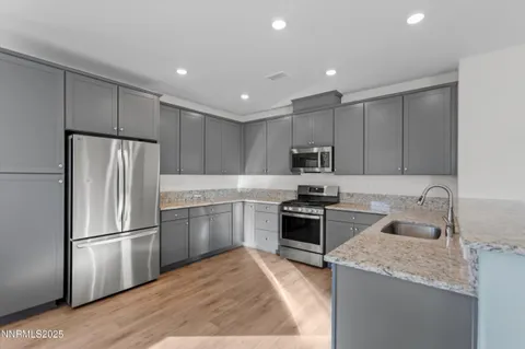 a kitchen with granite countertop stainless steel appliances and wooden cabinets