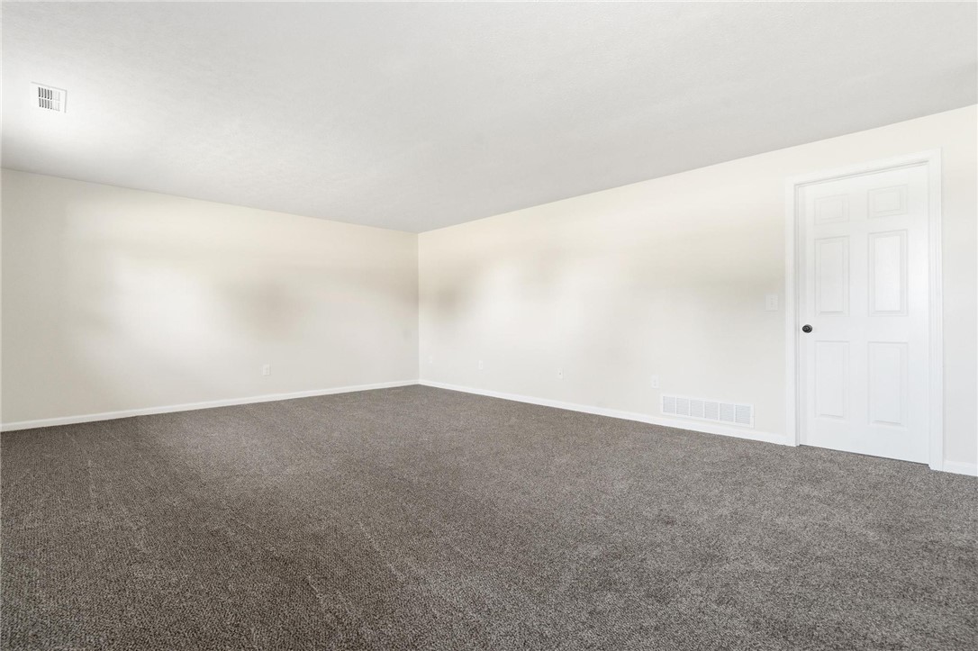 1353 Foust Road Xenia, OH 45385 - Photo 47 of 50 This spacious living area features fresh carpeting and a pristine white door, ready for your personal touch.