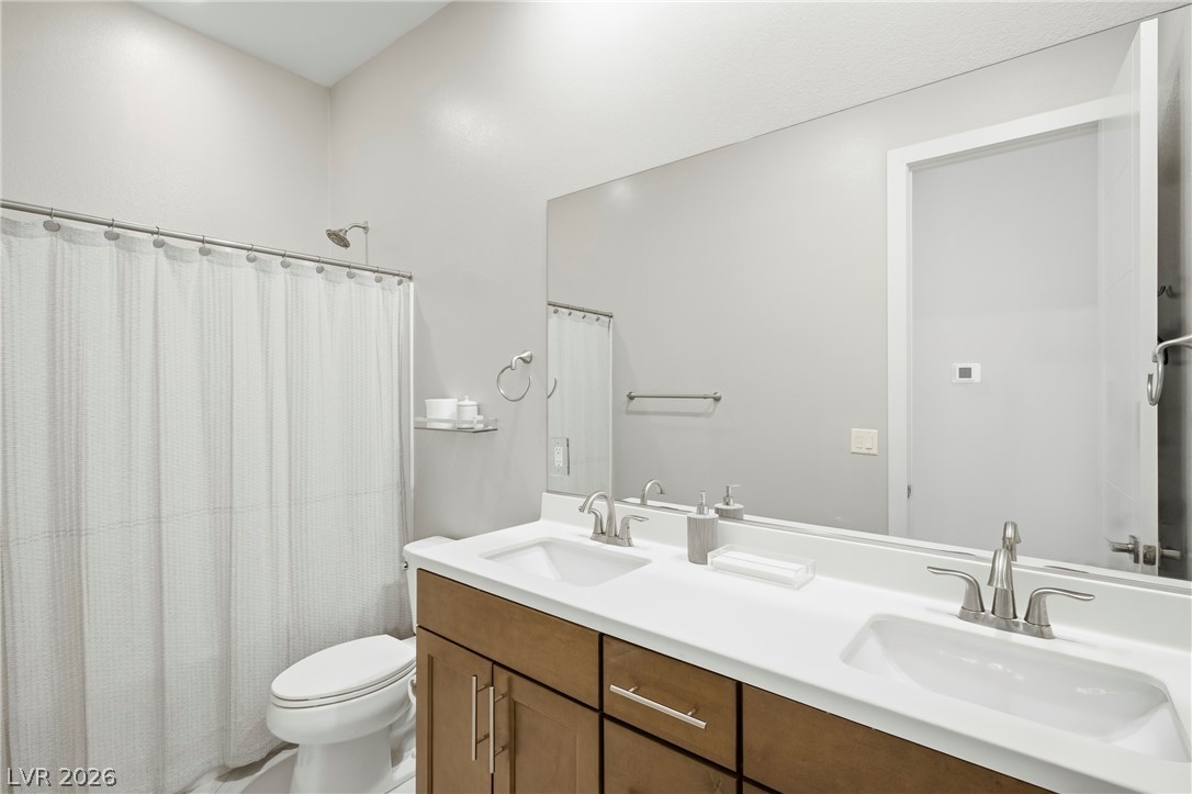 45 Garibaldi Way Henderson, NV 89011 - Photo 14 of 74 A well-appointed bathroom features a double vanity and a shower-tub combination.