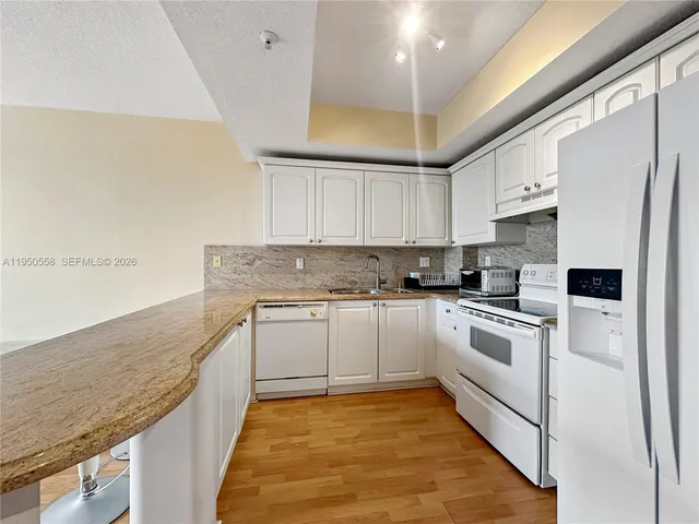 a kitchen with stainless steel appliances granite countertop a stove a sink and a refrigerator