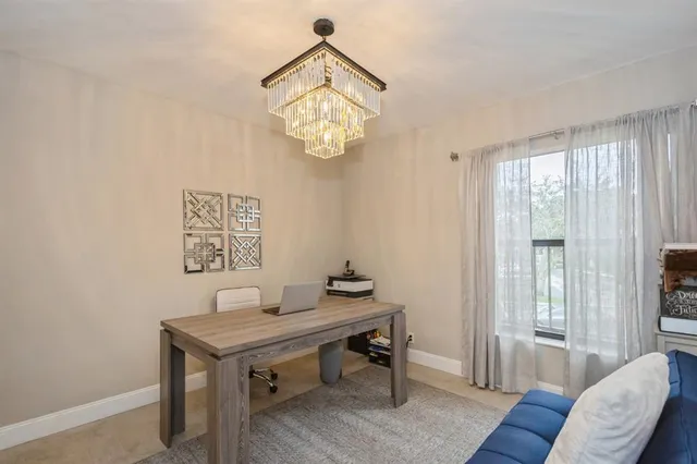 a view of a workspace with furniture and a window