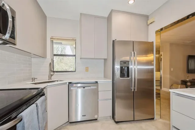 a kitchen with white cabinets and stainless steel appliances
