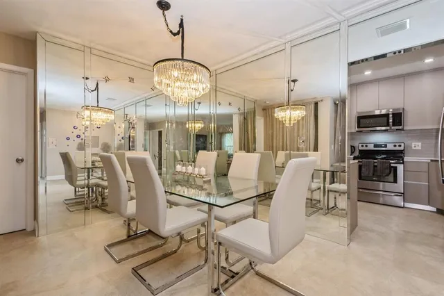 a view of a dining room and livingroom with furniture wooden floor a chandelier