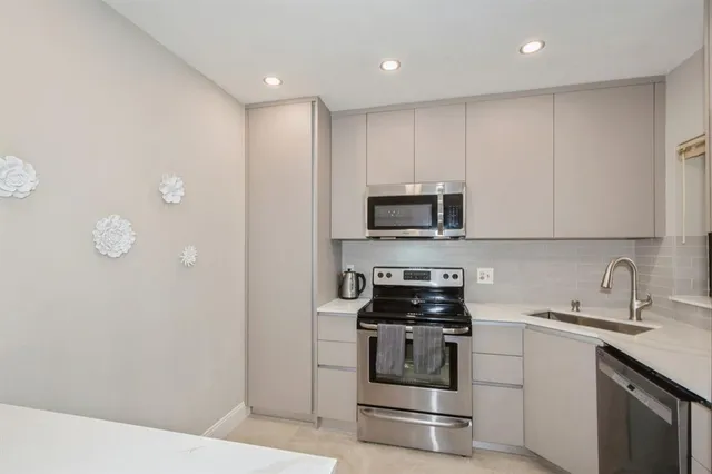 a kitchen with appliances a sink and cabinets