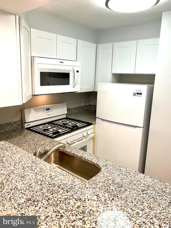 a kitchen with a stove and white cabinet