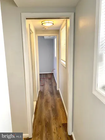 a view of a hallway with wooden floor and a window
